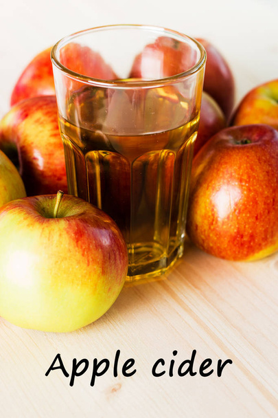 Glass of fresh apple cider  near autumn apples. Wooden background, text apple cider. Autumnal background. - Fotoğraf, Görsel