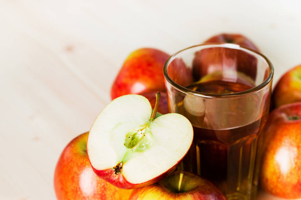 Bardak taze elma suyu ve sonbahar elma yakınındaki yarım elma. Ahşap arka plan, metin için yer. Arka plan. - Fotoğraf, Görsel