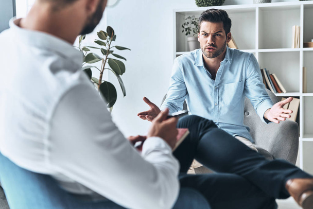 angry man having therapy session with psychologist consultant    - Foto, imagen