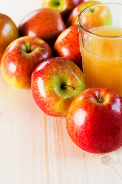 Bicchiere di sidro di mele fresco vicino alle mele autunnali. Sfondo in legno, vista dall'alto, spazio per il testo
. - Foto, immagini