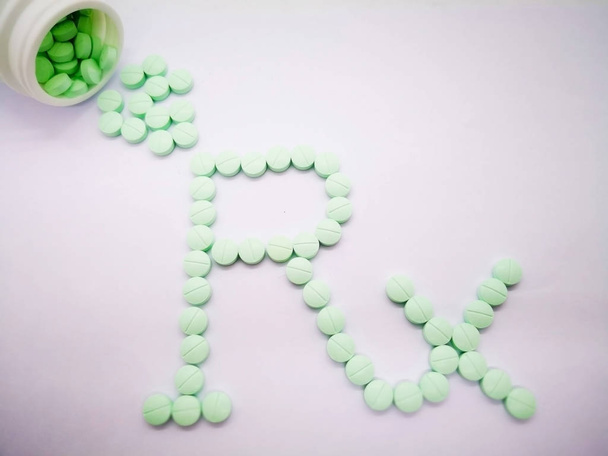 Gyógyszertár szimbólum, Rx szó által könnyű zöld tabletta elszigetelt fehér background. másol hely és a szelektív. - Fotó, kép