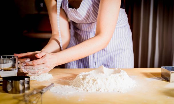 Making dough by female hands on kitchen table, close up - Φωτογραφία, εικόνα