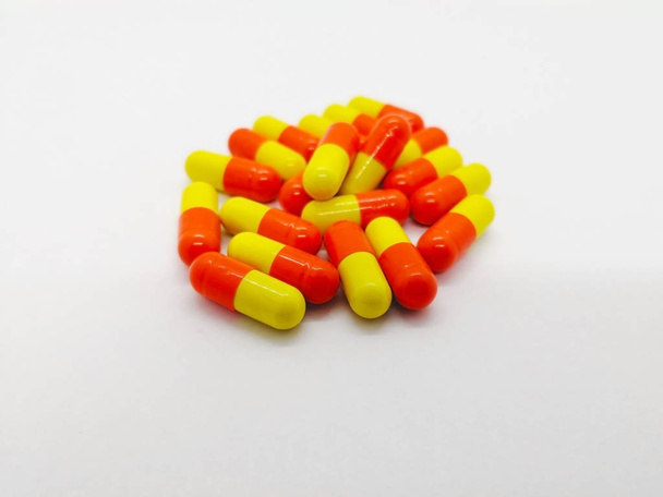 Médicaments et concept de santé. Beaucoup de capsules jaune orangé de tétracycline 250 mg isolées sur fond blanc, utilisées pour traiter de nombreuses infections bactériennes différentes. Mettre l'accent sur l'avant-plan et copier l'espace
. - Photo, image