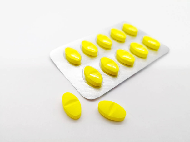 Medication and healthcare concept. Many yellow pills of  Paracetamol (Acetaminophen) 450 mg combined with Orphenadrine 35 mg . isolated on white background, used to treat injuries and other painful muscular conditions. Focus on foreground and copy sp - Foto, imagen