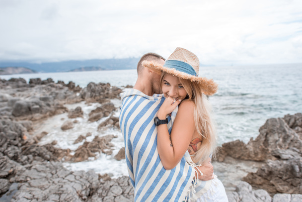 a fiatalember átölelve szép, mosolygós barátnője, a sziklás strandok montenegro - Fotó, kép