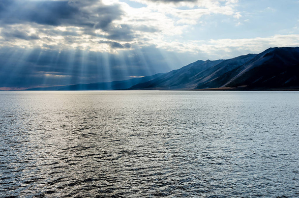 Sun, átszűrődő vastag felhős ég, a vigasz, a Bajkál-tó - Fotó, kép