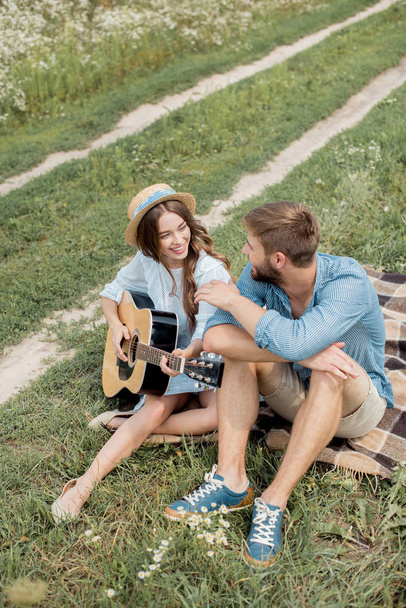 sonriente mujer jugando guitarra acústica a novio en verano archivado
 - Foto, Imagen