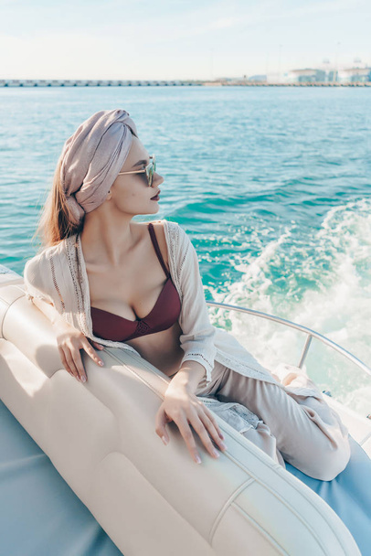 a luxurious sexy girl sails on the blue sea, enjoys a vacation - Zdjęcie, obraz