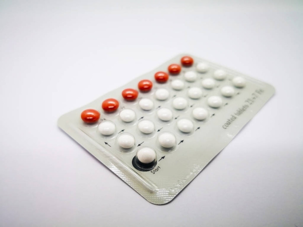 Oral contraceptive drug. 21 white pills consist of Ethinyl estradiol 0.035 mg. and Levonogestrel 0.15  mg. and 7 brown pill with Ferrous fumarate, for birth control. Abortion problem concept. Isolated on white background and Selective focus. - Photo, Image