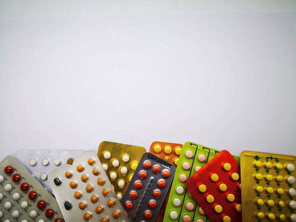 Koncept léky a zdravotní péče. Hromadu barevných perorální antikoncepce lék v barevné puchýře, antikoncepce. Pojem potrat problém. Izolované na bílém pozadí a kopie prostoru. - Fotografie, Obrázek