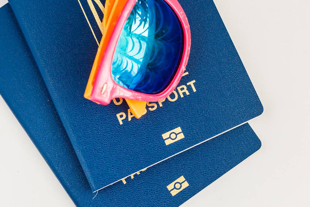 biometric passports and colorful sunglasses on white background, travel concept - Zdjęcie, obraz