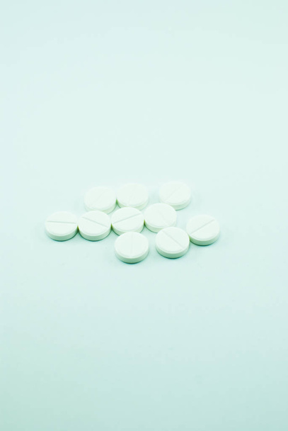 Stapel witte pillen op lichte blauwe achtergrond - Foto, afbeelding