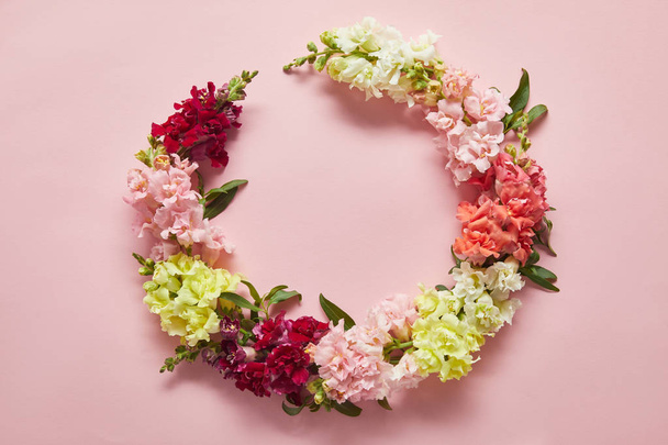close-up view of tender wreath of beautiful fresh flowers on pink - Photo, Image
