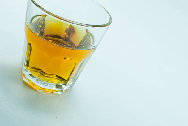 Glass of golden whisky on white background  - 写真・画像