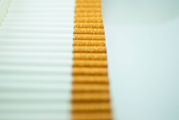 Кілька білих сигарет (туби) з жовтими фільтрами поспіль. Ізольовані
 - Фото, зображення