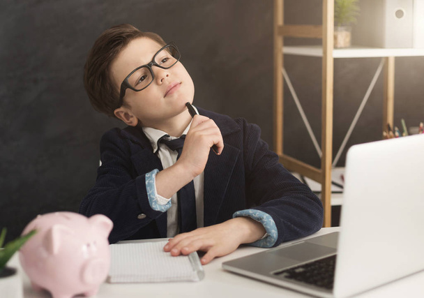 Little boy in suit thinking about finance - Foto, afbeelding