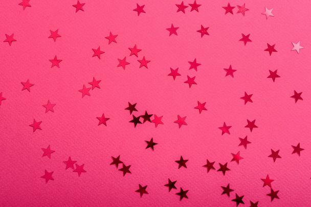 Star sprinkles on pink. Festive holiday background. Celebration concept. Top view, flat lay.  - Photo, image