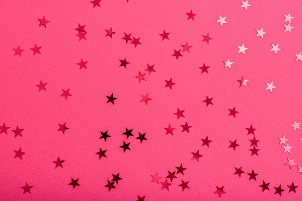 Star sprinkles on pink. Festive holiday background. Celebration concept. Top view, flat lay.  - Foto, Bild