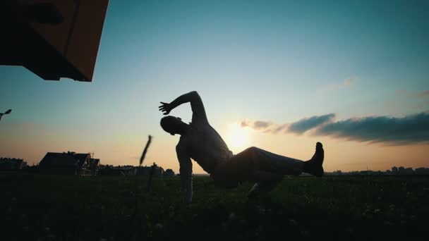 Yetenekli adam Capoeira çimenlerin üzerinde günbatımında, yaz dans. - Video, Çekim