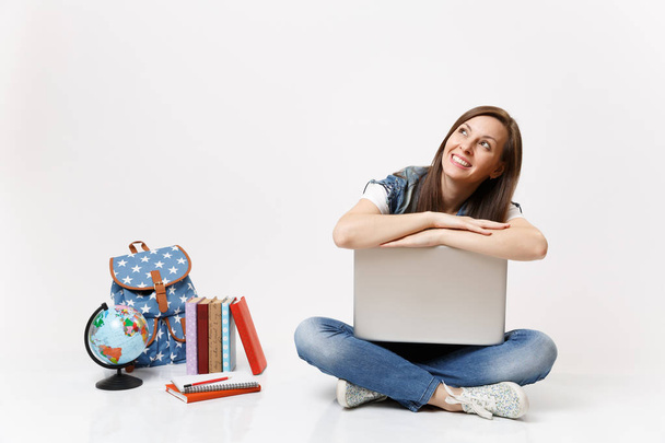 Young casual cheerful woman student lean on laptop pc computer looking up dreaming sitting near globe, backpack, school books isolated on white background. Education in high school university college - Photo, image