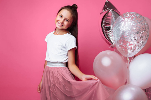 Beautiful little girl, with balls on pink background - Foto, Imagem