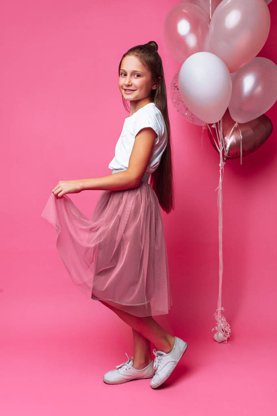 teen girl in beautiful dress on pink background - Foto, afbeelding