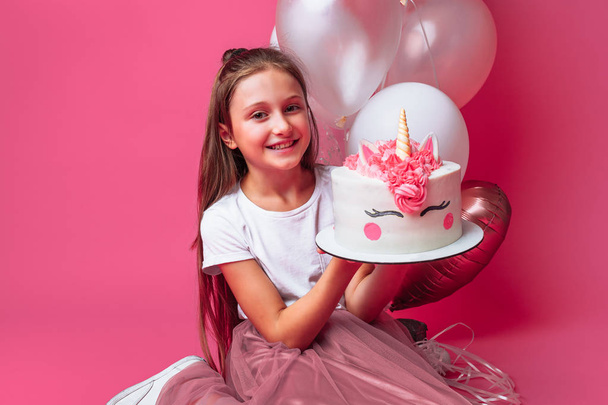 girl with a cake for a birthday, in the Studio on a pink background - Photo, image