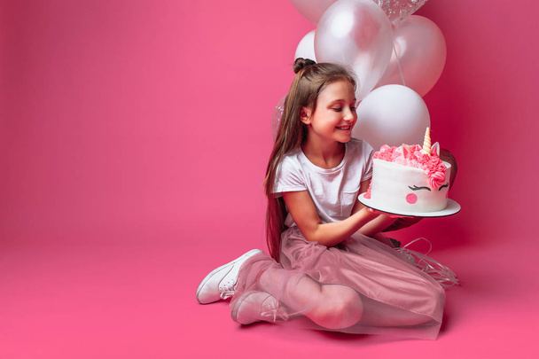 girl with a cake for a birthday, in the Studio on a pink background - Photo, Image