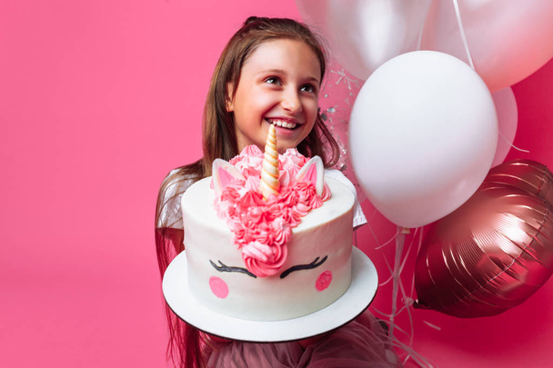 girl with a cake for a birthday, in the Studio on a pink background - Foto, immagini