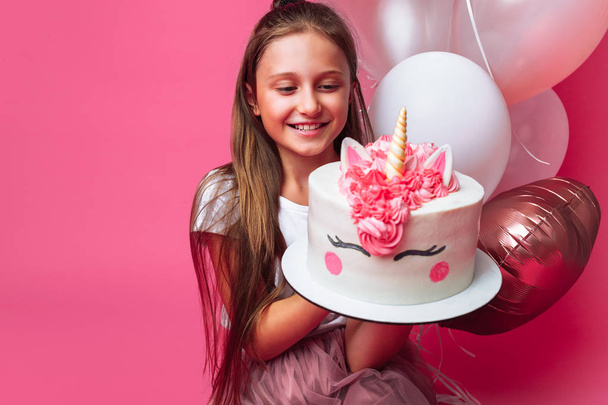 girl with a cake for a birthday, in the Studio on a pink background - Fotoğraf, Görsel