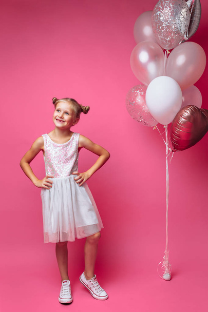 portrait of a little girl with balls, on a pink background in a photo Studio - Fotografie, Obrázek