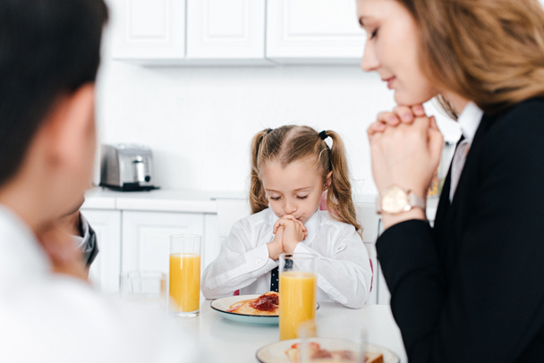 Teilansicht des gemeinsamen Gebets der Familie beim Frühstück zu Hause - Foto, Bild