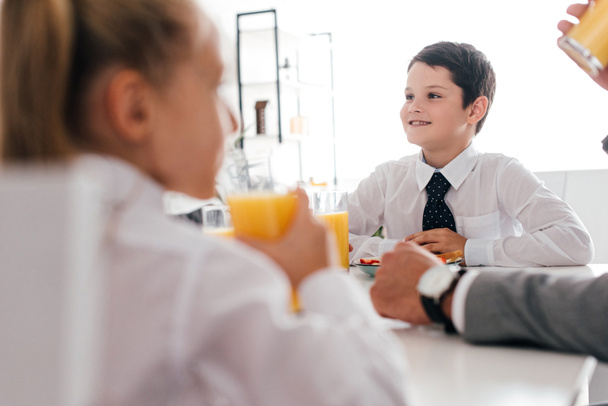 visão parcial do pai e das crianças em uniforme escolar tomando café da manhã em casa
 - Foto, Imagem