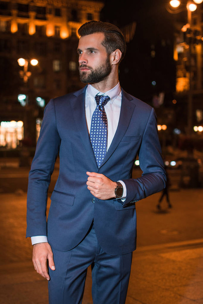 Style and business. Handsome young man looking away while standing outdoors - Фото, зображення
