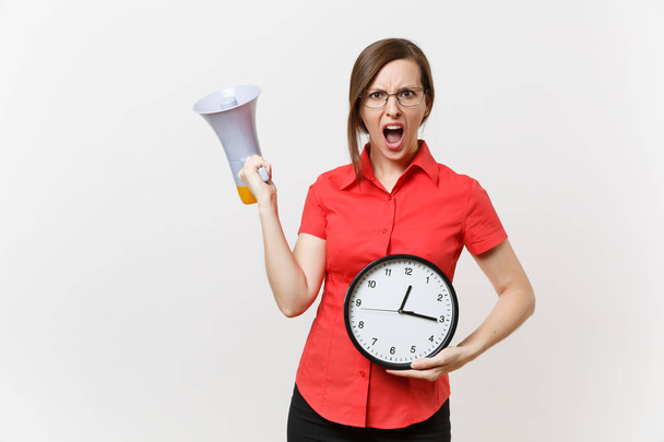 Portrait of young business teacher woman in red shirt holding round clock, scream in megaphone, announces discounts sale, isolated on white background. Hot news, communication concept.. Hurry up - Photo, Image