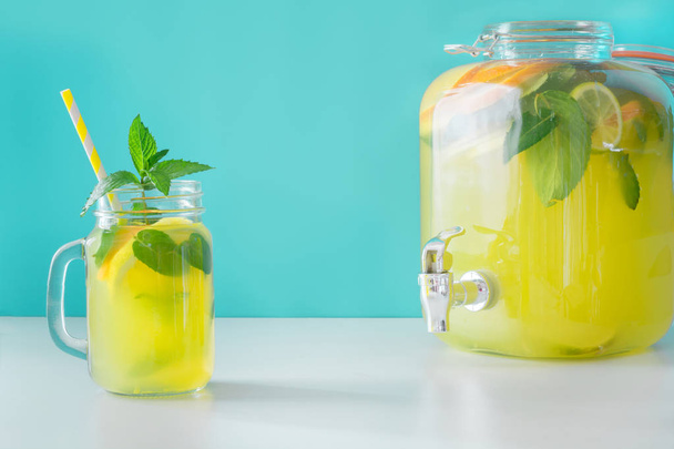 Lemonade in mason jar with lemon and mint on blue. Copy space. - Fotoğraf, Görsel