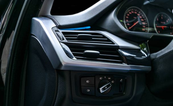 AC a luxus modern autó belső szellőzés fedélzet. Modern autó belső részleteket, fekete és fekete bőr varrás. Szén-dioxid-panel. Perforált bőr - Fotó, kép