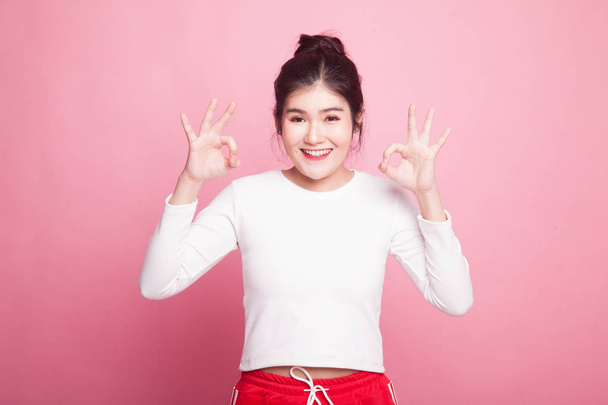 Asian woman show double OK hand sign  and smile on pink background - Photo, image