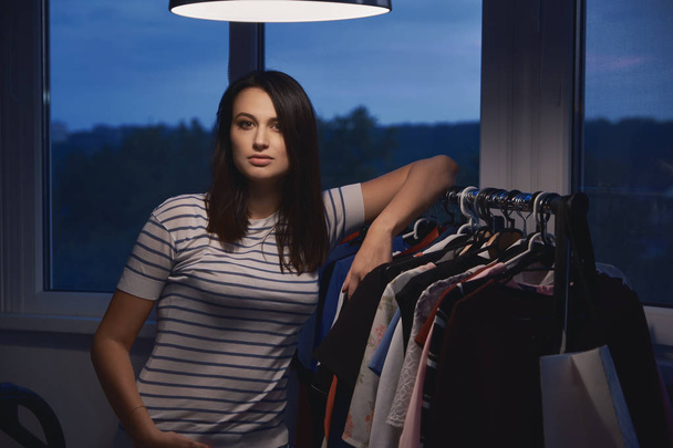Nuori nainen päättää työpäivänsä vaatteiden studiossa
 - Valokuva, kuva