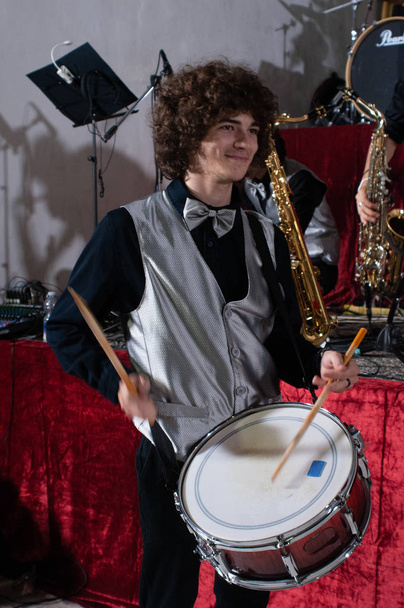 young drummer while testing his musical instrument, handsome guy while testing his instrument, snare drum - Foto, afbeelding
