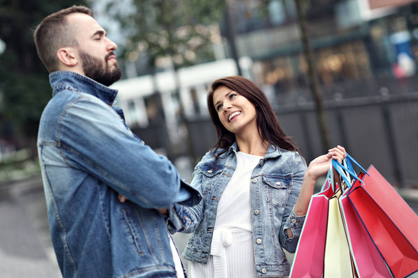 Retrato de pareja feliz con bolsas de compras después de comprar en la ciudad - Foto, Imagen