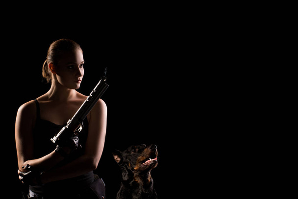 Στρατιωτική γυναίκα με ένα πυροβόλο όπλο αθλητισμού πέρα από το μαύρο φόντο. Σκιά. Χώρο αντίγραφο - Φωτογραφία, εικόνα