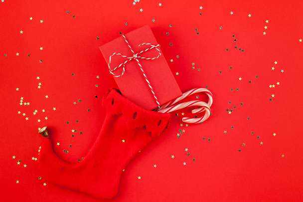 Δημιουργικό νέο έτος Χριστούγεννα κορδέλα τυλιγμένο παρουσιάζει επίπεδη θέσει το top view 2019 Χριστούγεννα διακοπές γιορτή χειροποίητο δώρο κουτιά noel κάλτσα copyspace φόντο κόκκινο χαρτί. Πρότυπο σχέδιο κειμένου ευχετήρια κάρτα - Φωτογραφία, εικόνα