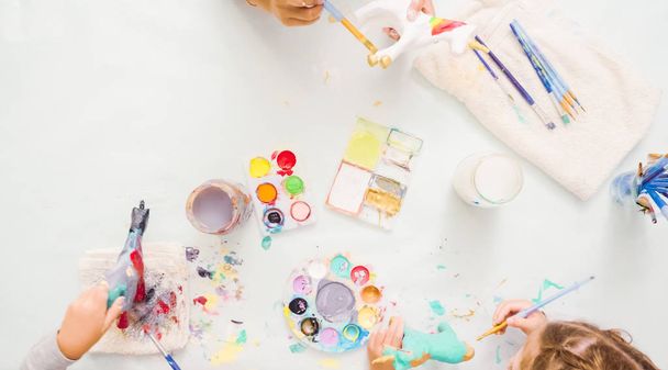 Βήμα-βήμα. Κοριτσάκια ζωγραφική μονόκερος mache χαρτί με ακρυλικά χρώματα. - Φωτογραφία, εικόνα