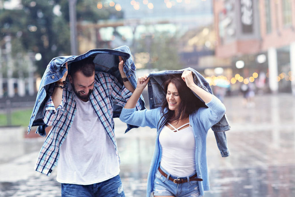 Joyeux couple courant sous la pluie dans la ville
 - Photo, image