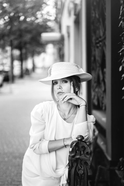 Pretty woman in white vintage dress walking on the street - Foto, immagini