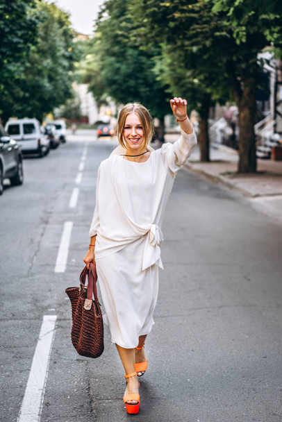 Pretty woman in vintage white dress walking outdoor - Foto, Imagen