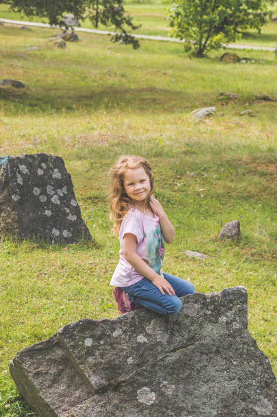 girl, a child in the Park climbed on the stones - Fotoğraf, Görsel