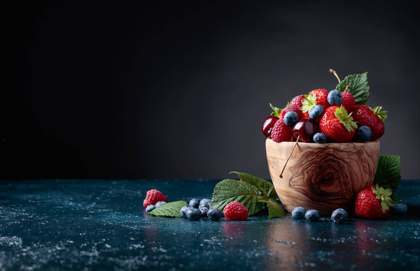 Berries closeup colorful assorted mix of strawberry, blueberry, raspberry and sweet cherry in studio on dark background. - Zdjęcie, obraz
