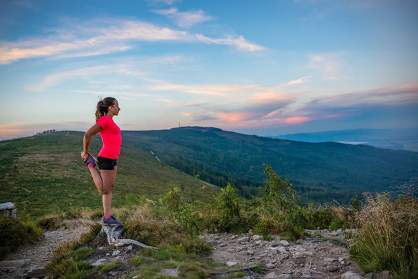 Woman stretching after trail running in mountains. Szczyrk, Beskidy Mountains, Silesian Beskid, Poland - Photo, Image